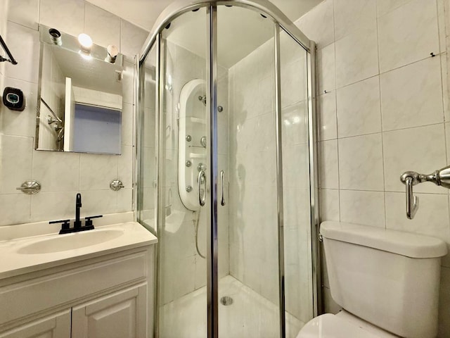 132-06 57th Rd, Flushing, NY 11355 - bathroom featuring tile walls, toilet, vanity, a shower stall, and backsplash