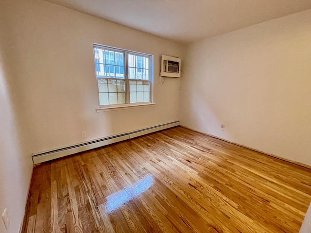132-06 57th Rd, Flushing, NY 11355 - unfurnished room with a baseboard radiator, a wall unit AC, and wood finished floors