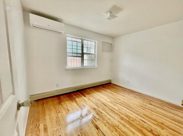 132-06 57th Rd, Flushing, NY 11355 - spare room with an AC wall unit, baseboard heating, wood finished floors, and baseboards