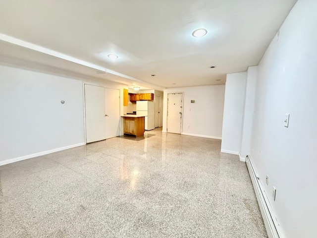 132-06 57th Rd, Flushing, NY 11355 - unfurnished living room with a baseboard heating unit, dark speckled floor, and baseboards