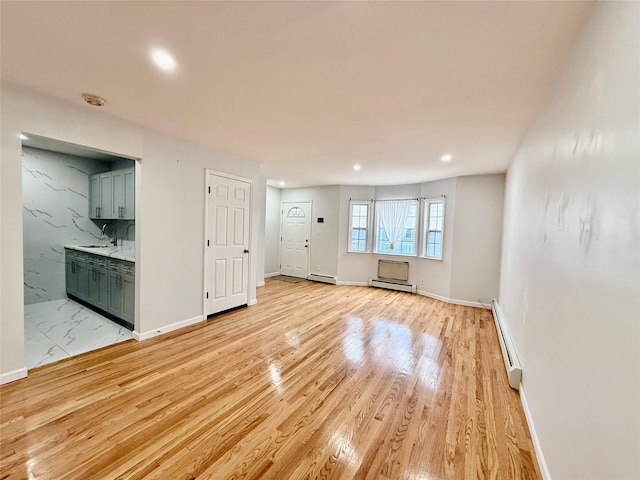 132-06 57th Rd, Flushing, NY 11355 - unfurnished living room featuring baseboard heating, recessed lighting, a sink, baseboards, and light wood-type flooring