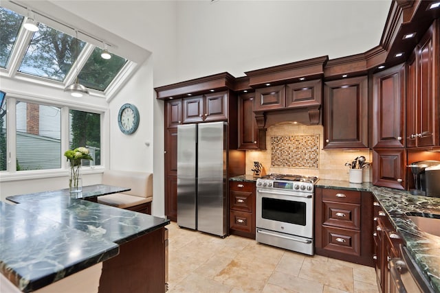 8 Ellis Dr, Syosset, NY 11791 - kitchen featuring appliances with stainless steel finishes, a skylight, tasteful backsplash, plenty of natural light, and a high ceiling