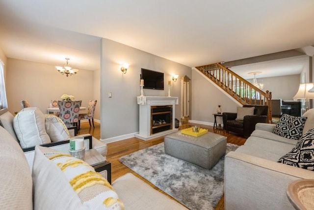 532 7th St, West Hempstead, NY 11552 - living room with a chandelier, stairway, wood finished floors, and a fireplace