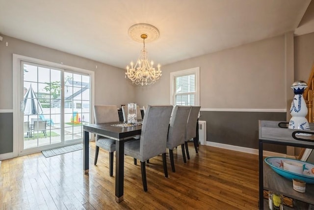 532 7th St, West Hempstead, NY 11552 - dining area featuring wood-type flooring, healthy amount of natural light, a chandelier, and radiator heating unit