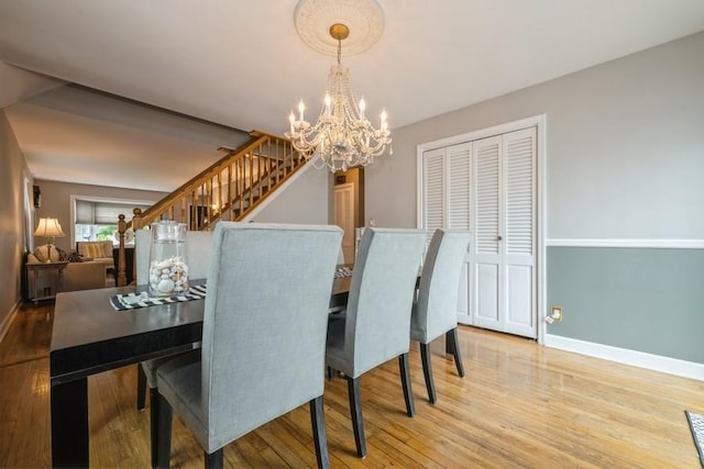 532 7th St, West Hempstead, NY 11552 - dining space featuring a chandelier, light wood-type flooring, and stairs