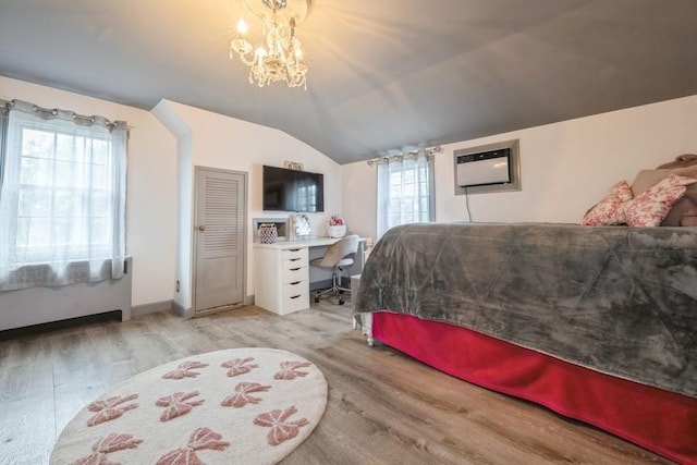 532 7th St, West Hempstead, NY 11552 - bedroom with wood finished floors, lofted ceiling, a wall mounted air conditioner, a desk, and a chandelier