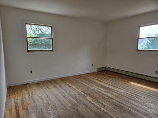 18 Laura Ct, Nesconset, NY 11767 - unfurnished room featuring hardwood / wood-style flooring, plenty of natural light, and a baseboard heating unit