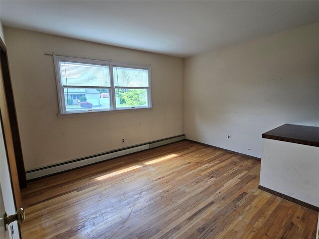 18 Laura Ct, Nesconset, NY 11767 - empty room featuring baseboard heating and hardwood / wood-style flooring