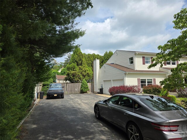 18 Laura Ct, Nesconset, NY 11767 - view of side of home featuring asphalt driveway and a garage