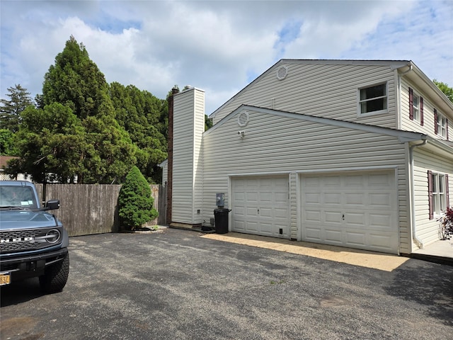 18 Laura Ct, Nesconset, NY 11767 - view of property exterior featuring a garage, asphalt driveway, and a chimney