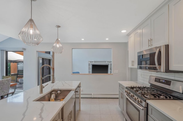 318 Sheep Pasture Rd, East Setauket, NY 11733 - kitchen featuring appliances with stainless steel finishes, hanging light fixtures, a sink, light stone counters, and baseboard heating