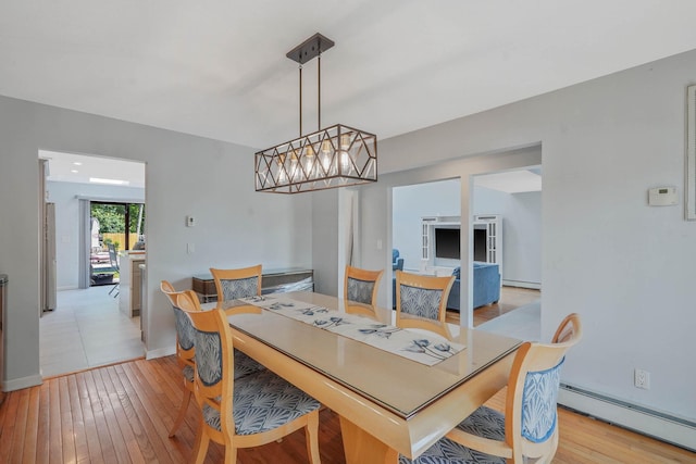 318 Sheep Pasture Rd, East Setauket, NY 11733 - dining space with a baseboard heating unit, light wood-style flooring, and baseboards