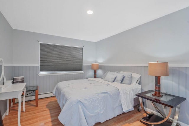 318 Sheep Pasture Rd, East Setauket, NY 11733 - bedroom with wainscoting, wood finished floors, and a baseboard heating unit