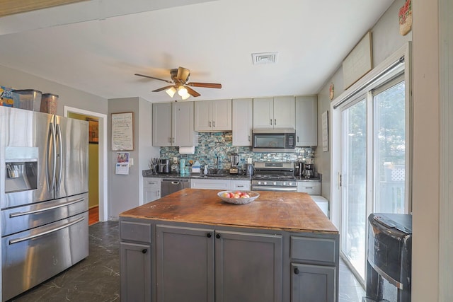 7 Tufts Ln, Highland Mills, NY 10930 - kitchen featuring stainless steel appliances, gray cabinetry, decorative backsplash, ceiling fan, and dark marble finish flooring