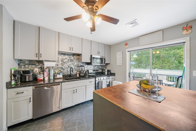 7 Tufts Ln, Highland Mills, NY 10930 - kitchen featuring appliances with stainless steel finishes, tasteful backsplash, a ceiling fan, and dark marble finish flooring