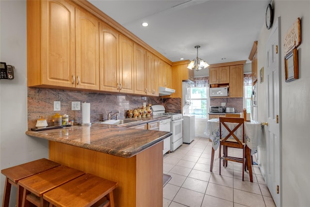 5-17 51st Ave, Long Island City, NY 11101 - kitchen featuring white appliances, a sink, under cabinet range hood, a peninsula, and tasteful backsplash