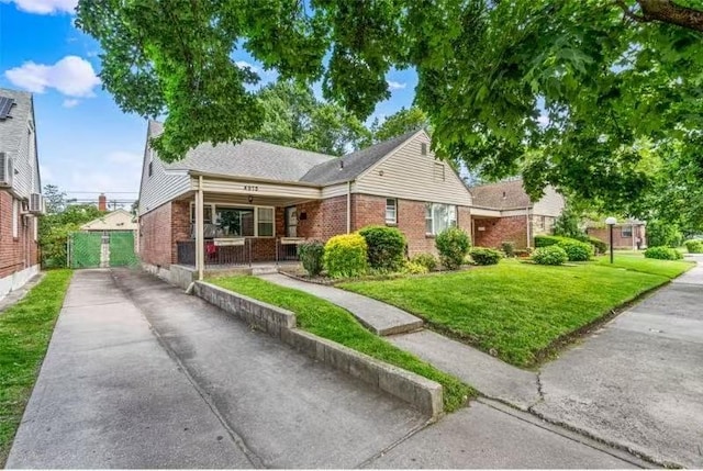 49-75 175th Pl, Fresh Meadows, NY 11365 - view of front of property featuring driveway, brick siding, a front yard, and covered porch