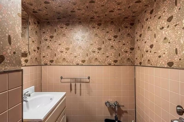 49-75 175th Pl, Fresh Meadows, NY 11365 - bathroom featuring wallpapered walls, vanity, tile walls, and wainscoting