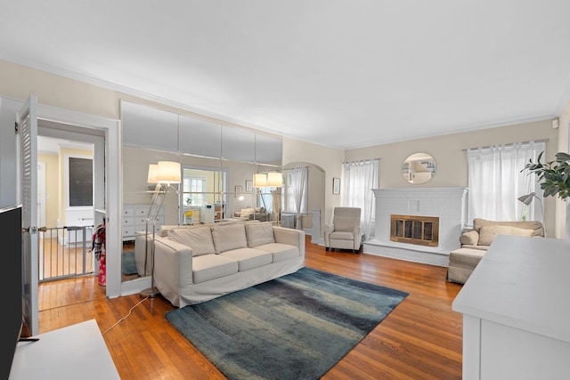 206 Brower Ave, Rockville Centre, NY 11570 - living area with wood finished floors, arched walkways, ornamental molding, and a fireplace