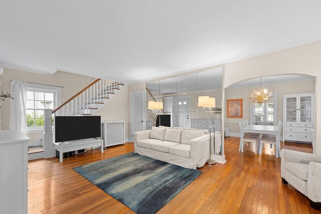 206 Brower Ave, Rockville Centre, NY 11570 - living room with arched walkways, ornamental molding, hardwood / wood-style floors, stairway, and a chandelier