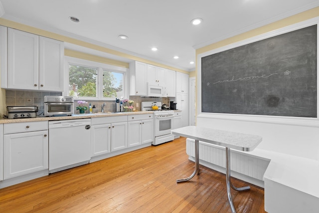 206 Brower Ave, Rockville Centre, NY 11570 - kitchen with white appliances, white cabinetry, light countertops, decorative backsplash, and crown molding