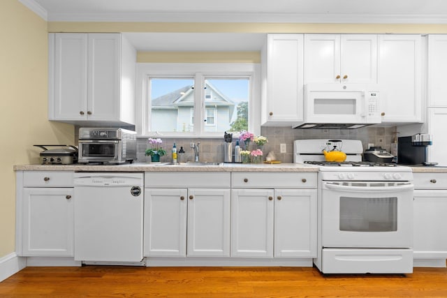 206 Brower Ave, Rockville Centre, NY 11570 - kitchen featuring white appliances, white cabinets, tasteful backsplash, light wood-type flooring, and crown molding