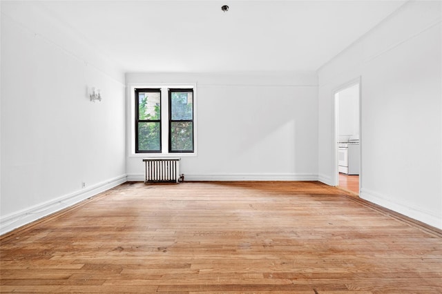 43 Calton Rd Unit 4J, New Rochelle, NY 10804 - unfurnished room with radiator heating unit, light wood-style flooring, and a pendent fire sprinkler