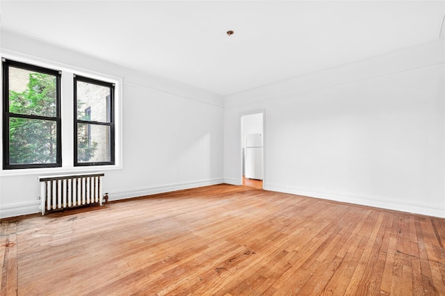 43 Calton Rd Unit 4J, New Rochelle, NY 10804 - spare room featuring radiator heating unit, light wood-type flooring, and baseboards
