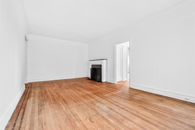 43 Calton Rd Unit 4J, New Rochelle, NY 10804 - unfurnished living room with light wood finished floors, a fireplace, and baseboards
