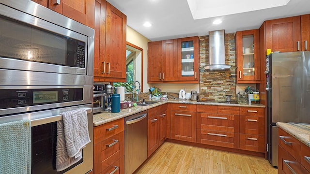 6 Sycamore Pl, Smithtown, NY 11787 - kitchen featuring appliances with stainless steel finishes, wall chimney range hood, light wood-style floors, light stone countertops, and recessed lighting