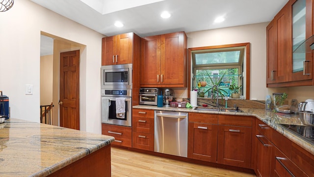6 Sycamore Pl, Smithtown, NY 11787 - kitchen featuring stainless steel appliances, light stone countertops, light wood-style floors, glass insert cabinets, and recessed lighting