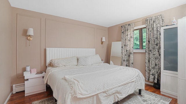6 Sycamore Pl, Smithtown, NY 11787 - bedroom featuring a baseboard heating unit and wood finished floors