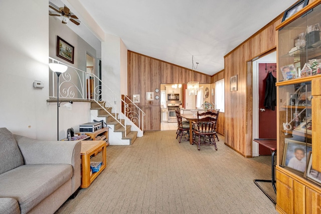 9 Laurie Rd, Brentwood, NY 11717 - carpeted living room with lofted ceiling, wood walls, stairs, and ceiling fan