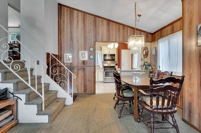 9 Laurie Rd, Brentwood, NY 11717 - dining room featuring wood walls, lofted ceiling, stairway, and a chandelier