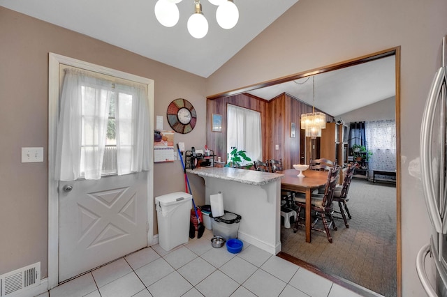 9 Laurie Rd, Brentwood, NY 11717 - kitchen featuring a chandelier, vaulted ceiling, light tile patterned flooring, hanging light fixtures, and light colored carpet