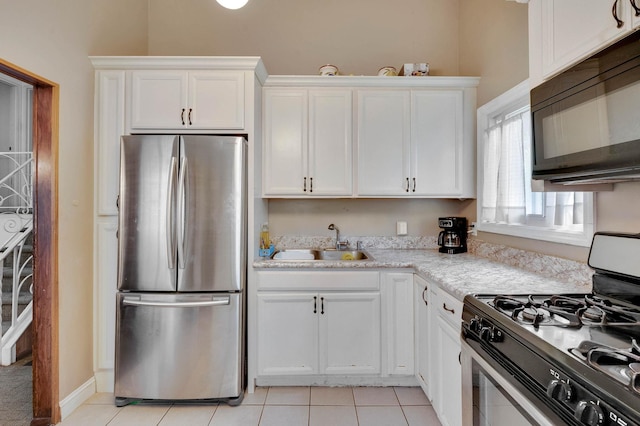 9 Laurie Rd, Brentwood, NY 11717 - kitchen featuring freestanding refrigerator, gas range oven, black microwave, and light tile patterned floors