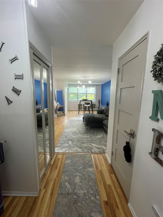 98 Dehaven Dr Unit 3G, Yonkers, NY 10703 - hall featuring light wood-type flooring, a chandelier, and baseboards