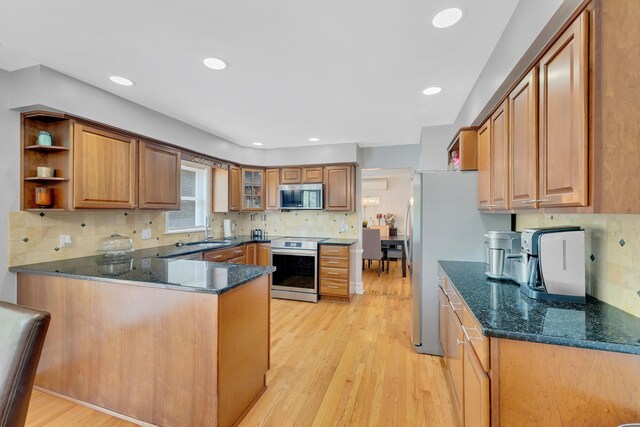 8 Mueller Mountain Rd, Putnam Valley, NY 10579 - kitchen with stainless steel appliances, a peninsula, backsplash, light wood-style flooring, and brown cabinetry