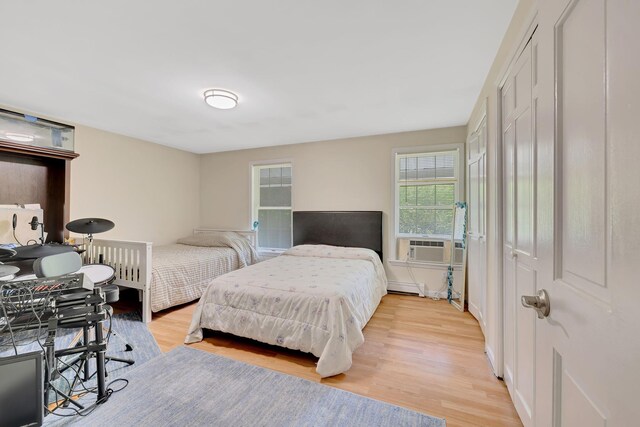 8 Mueller Mountain Rd, Putnam Valley, NY 10579 - bedroom with light wood-type flooring, baseboard heating, and cooling unit
