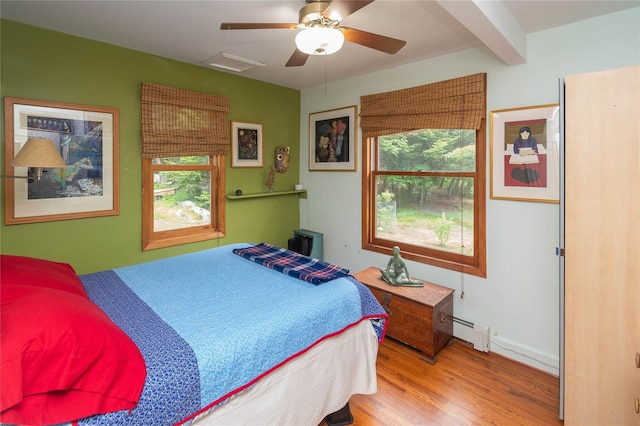 6807 State Route 42, Woodbourne, NY 12788 - bedroom featuring wood finished floors, multiple windows, a baseboard radiator, ceiling fan, and beam ceiling