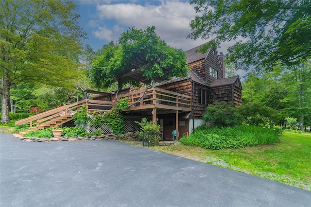 6807 State Route 42, Woodbourne, NY 12788 - view of property exterior featuring a deck, roof with shingles, and stairway