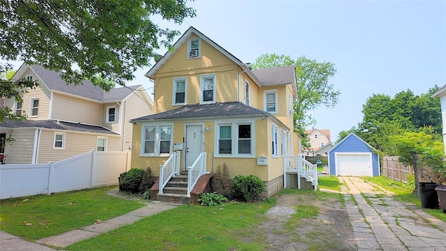 27 Charles St, Roosevelt, NY 11575 - view of front of property featuring asphalt driveway, stucco siding, and an outdoor structure