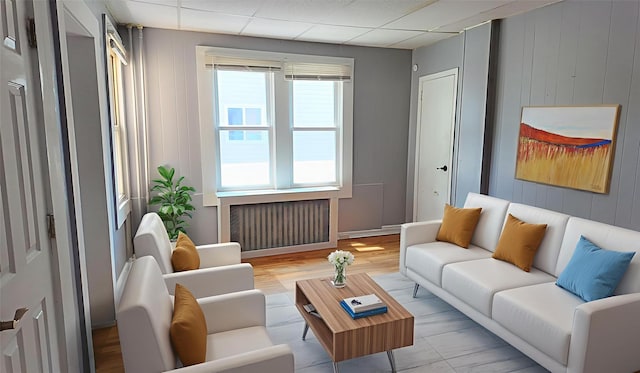 27 Charles St, Roosevelt, NY 11575 - living room with radiator, wood walls, and a drop ceiling