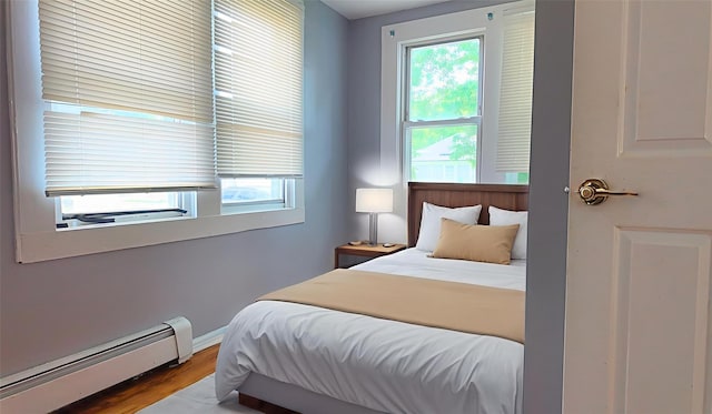 27 Charles St, Roosevelt, NY 11575 - bedroom featuring baseboard heating and wood finished floors