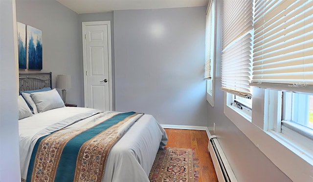 27 Charles St, Roosevelt, NY 11575 - bedroom with a baseboard radiator and wood finished floors