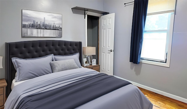 27 Charles St, Roosevelt, NY 11575 - bedroom featuring multiple windows and wood finished floors