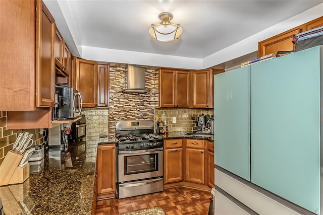 90 Charles St, Lynbrook, NY 11563 - kitchen with freestanding refrigerator, stainless steel gas range, wall chimney exhaust hood, backsplash, and brown cabinetry