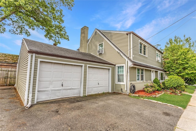 90 Charles St, Lynbrook, NY 11563 - view of front of property featuring an attached garage, asphalt driveway, and a chimney