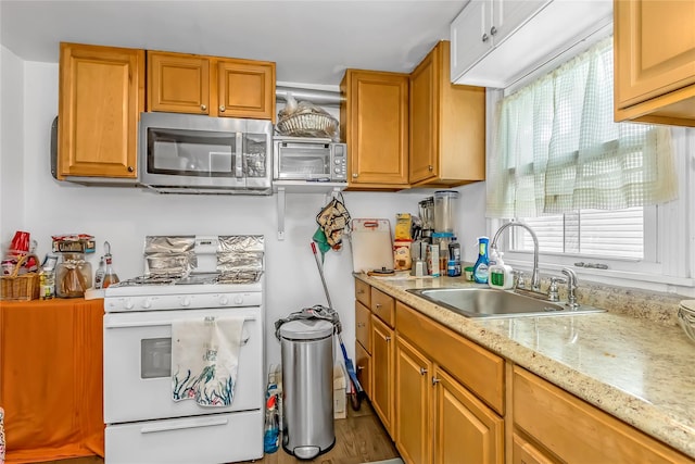 90 Charles St, Lynbrook, NY 11563 - kitchen with stainless steel microwave, white gas range, a sink, wood finished floors, and light stone counters