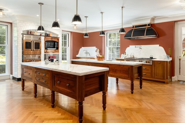 842 Sleepy Hollow Rd, Briarcliff Manor, NY 10510 - kitchen featuring a center island, ventilation hood, brown cabinets, crown molding, and decorative light fixtures